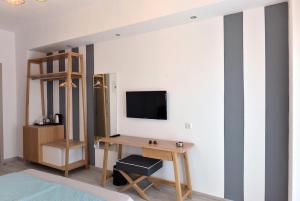 a room with a desk and a tv on a wall at Aqua Marine in Neos Marmaras