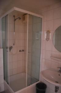 a bathroom with a shower and a tub and a sink at Hotel Johnel in Hennef