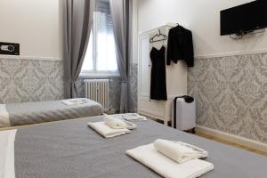 1 Schlafzimmer mit 2 Betten und einem Kleid, das am Fenster hängt in der Unterkunft Domus St. John in Rom