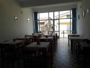 a room with tables and chairs and a large window at Parigino in Palinuro