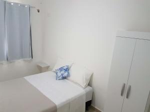 a small white room with a bed and a cabinet at Apartamento no Dalas Park Residencial in Campina Grande