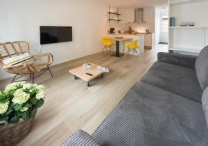 uma sala de estar com um sofá e uma mesa em Holiday Home Zuidstraat 30B em Westkapelle