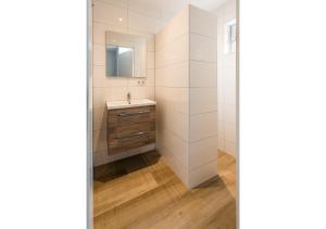 uma casa de banho com um lavatório e um espelho em Holiday Home Zuidstraat 30B em Westkapelle