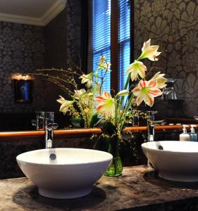 a bathroom with two sinks and flowers on a counter at The Royal Highland Hotel in Inverness