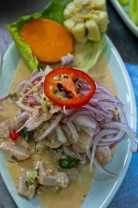 un plato de comida con ensalada y tomate en Hostal Huacachina Sunset, en Ica