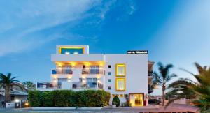 德尼亞的住宿－維拉莫爾酒店，一座白色的建筑,前面有棕榈树