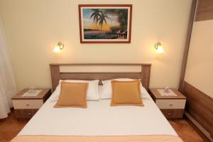 um quarto com uma cama branca com duas mesas de cabeceira em Apartment Carmen em Trogir