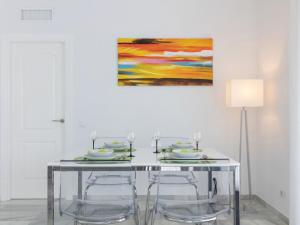 エステポナにあるApartment Alcazaba Beach by Interhomeのダイニングテーブル(椅子付)が備わります。壁には絵画が飾られています。