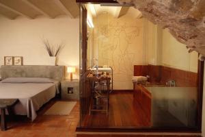 a bedroom with a bed and a glass shower at Hotel la Plaça Madremanya in Madremanya