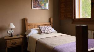 a small bedroom with a bed and a lamp and a window at Hotel La Gerencia in Checa