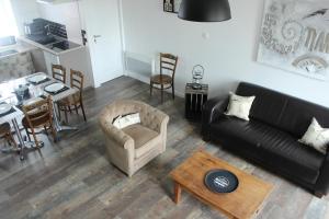 a living room with a couch and a chair and a table at A chacun son nid in Les Épesses