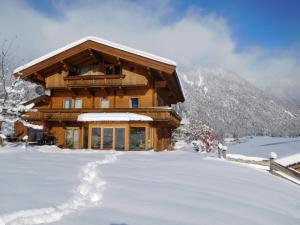 uma cabana de madeira na neve com muita neve em Apartment Aschaber em Waidring