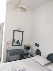 a bedroom with a bed and a desk and a mirror at Camares in Chora Folegandros