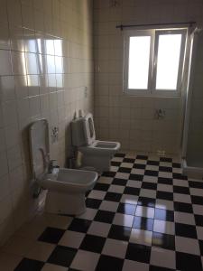 a bathroom with two toilets and a checkered floor at Sermar in Rabo de Peixe