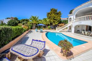 a villa with a swimming pool and a house at La Perla - sea view villa with private pool in Moraira in Moraira