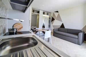 a kitchen and living room with a sink and a couch at Lux apartments in Porto Cesareo