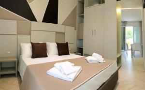 um quarto com uma cama grande e toalhas em Lux apartments em Porto Cesareo