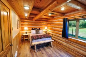 um quarto com uma cama num chalé de madeira em Paddle Ridge em West Glacier