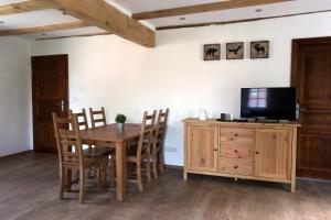 a dining room with a wooden table and a tv at Altes -Haus in Gattendorf