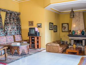 sala de estar con sofás, TV y chimenea en Kasbah Idriss, en Ouarzazate