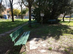 ピサにあるCisanello Houseの公園内に座る緑の公園ベンチ2つ