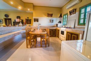 cocina grande con mesa de madera y sillas en Kasbah Idriss, en Ouarzazate