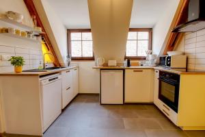 a large kitchen with white cabinets and appliances at La Grange de Madeleine in Eguisheim +9 photos