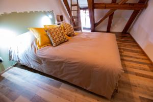 een bed met gele kussens in een kamer bij La Grange de Madeleine in Eguisheim