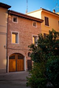 a brick building with a large wooden garage at Callegherie 21 Boutique B&B in Imola