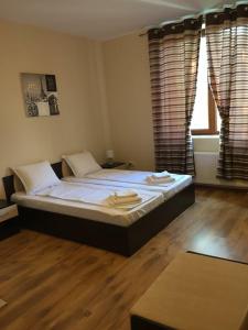 a large bed in a room with wooden floors and windows at Amigos in Pawlikeni