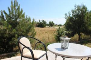 a white table and chairs with a lantern on it at Vakis Apartments in Romanón