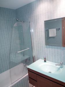 a bathroom with a sink and a shower and a tub at Fun & Sun Apartment in Olhão