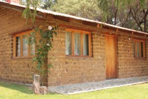 una casa de ladrillo con una puerta y hiedra en ella en El Huariche, en Huasca de Ocampo