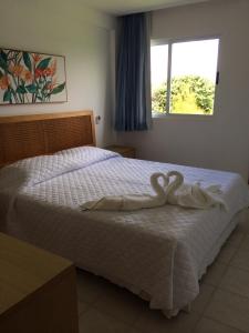 Un dormitorio con una cama con una decoración de corazón. en Muro Alto Marupiara Flats Porto de Galinhas, en Porto de Galinhas