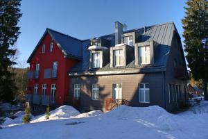 una grande casa con una casa rossa nella neve di Resort 302 a Harrachov