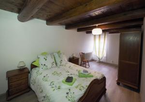 1 dormitorio con 1 cama grande y techo de madera en La ferme aux volets bleus, en Mainvillers