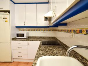 uma cozinha com armários brancos e um lavatório em Holiday Home Dunasol by Interhome em Casas Devesa