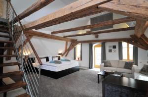 a living room with a bed and a staircase at Hotel Herrnschloesschen in Rothenburg ob der Tauber
