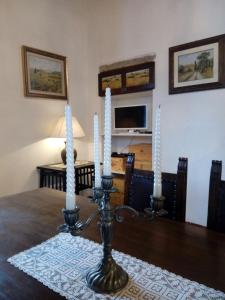 a candle holder on a table with three candles on it at Torre rossa in Bolgheri