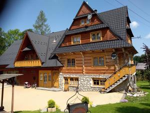 a large wooden house with a gambrel roof at Gospodarstwo Agroturystyczne Michniak in Dzianisz