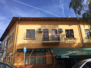 a yellow building with two balconies on a street at Amigos in Pawlikeni