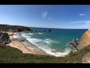 a view of a beach with rocks and the ocean at Casa Sto. António in Zambujeira do Mar +7 photos
