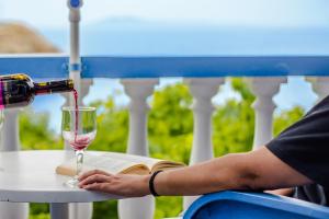 een persoon giet wijn in een wijnglas bij Villa George in Batsi