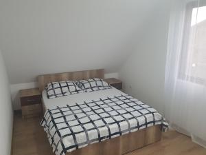um quarto com uma cama com um edredão preto e branco em Cabana Soral Baile Figa em Beclean