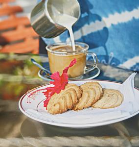 a plate with cookies and a cup of coffee at Plaza Beach Hotel in Bamburi