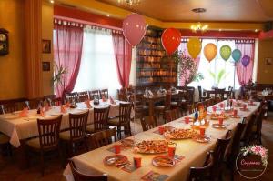 un comedor con mesas, sillas y globos en Amigos, en Pawlikeni