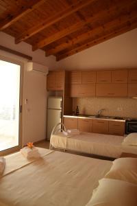 a room with two beds and a kitchen with a window at Belvedere Adriatica in Qeparo