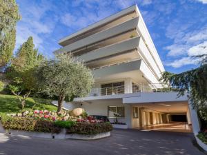 a white house with a tree and flowers at Apartment Les Hortensias by Interhome in Cannes