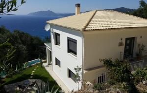 a white house with a view of the ocean at Villa Olivia in Pentati