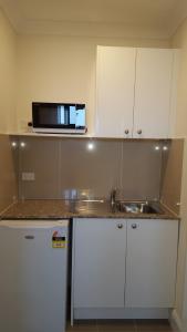 a kitchen with a sink and a microwave at Bathurst Gold Panner in Bathurst +67 photos